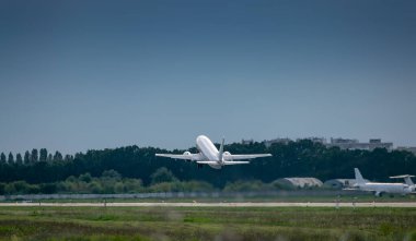 Yolcu uçağı bulutlu bir günde havaalanından kalkıyor.
