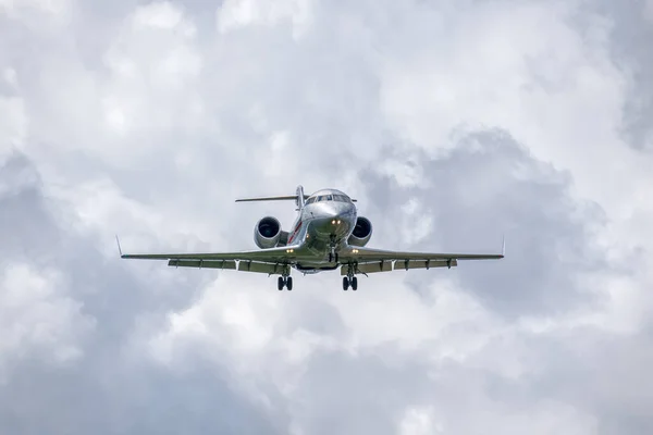 Business jet is landing with clouds on the background