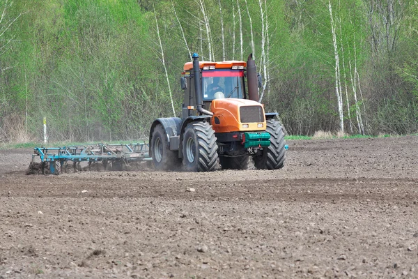 Traktor obdělávající půdu — Stock fotografie