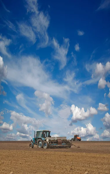 Tractors cultivating field — Stock Photo, Image