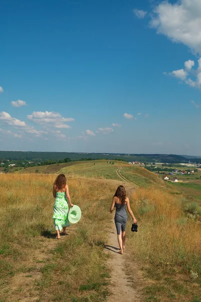 Two girls walking down the hill — Stock Photo, Image