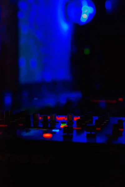 Misturador de DJ com auscultadores na discoteca. Na luz laser de fundo — Fotografia de Stock