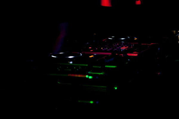 DJ mixer met een koptelefoon bij nightclub. In de achtergrond-laserlicht — Stockfoto