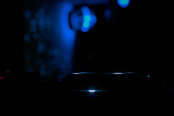 Misturador de DJ com auscultadores na discoteca. Na luz laser de fundo — Fotografia de Stock
