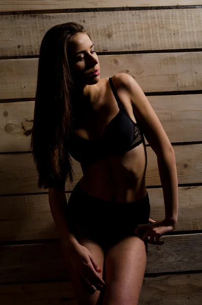 Cilalı kurullarının bir arka plan üzerinde siyah bir mayo içinde güzel seksi kız — Stok fotoğraf