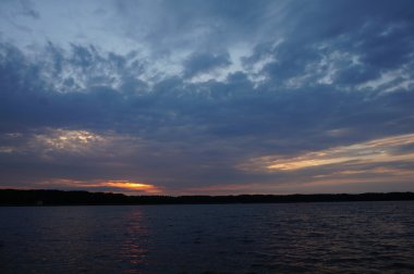 Zaman atlamalı olarak büyük güneş batmadan okyanus üzerinde ufuk içine büyük turuncu günbatımı