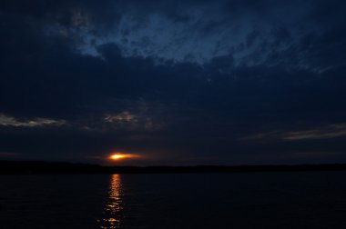 Zaman atlamalı olarak büyük güneş batmadan okyanus üzerinde ufuk içine büyük turuncu günbatımı