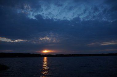 Zaman atlamalı olarak büyük güneş batmadan okyanus üzerinde ufuk içine büyük turuncu günbatımı