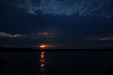 Zaman atlamalı olarak büyük güneş batmadan okyanus üzerinde ufuk içine büyük turuncu günbatımı