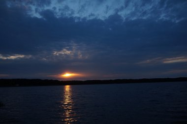 Zaman atlamalı olarak büyük güneş batmadan okyanus üzerinde ufuk içine büyük turuncu günbatımı