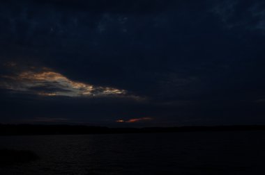 Zaman atlamalı olarak büyük güneş batmadan okyanus üzerinde ufuk içine büyük turuncu günbatımı