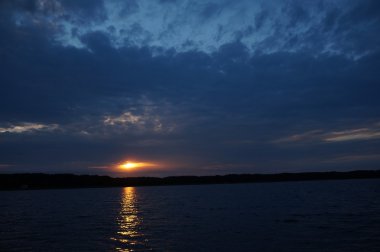 Zaman atlamalı olarak büyük güneş batmadan okyanus üzerinde ufuk içine büyük turuncu günbatımı