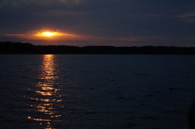 Zaman atlamalı olarak büyük güneş batmadan okyanus üzerinde ufuk içine büyük turuncu günbatımı