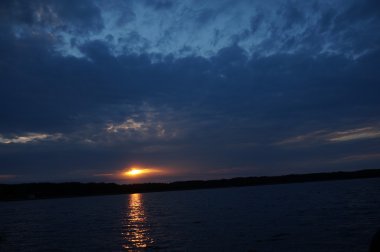 Zaman atlamalı olarak büyük güneş batmadan okyanus üzerinde ufuk içine büyük turuncu günbatımı