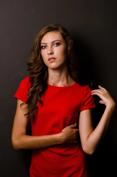 Mooie vrouw met donker haar en avondmake-up. Juwelen schoonheid. Modefoto. zwarte achtergrond, sexy rode jurk — Stockfoto