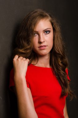 Koyu saçlı ve akşam makyajlı güzel bir kadın. Mücevher güzeli. Moda fotoğrafı. Siyah arka plan, seksi kırmızı elbise