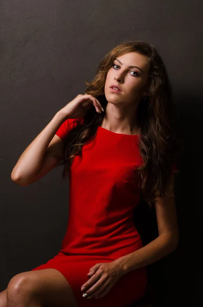 Mooie vrouw met donker haar en avondmake-up. Juwelen schoonheid. Modefoto. zwarte achtergrond, sexy rode jurk — Stockfoto