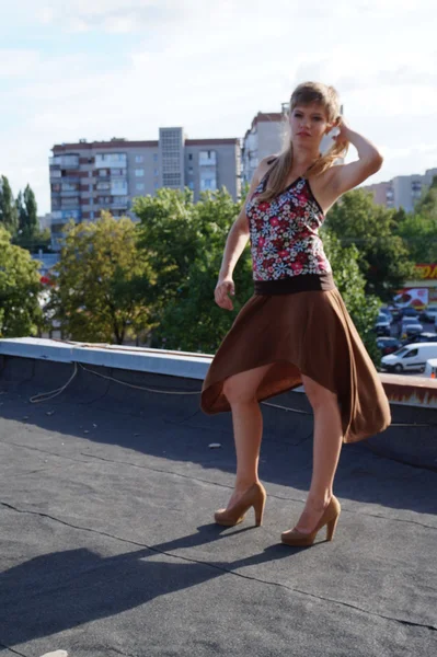 美丽时尚性感的女孩穿高跟鞋玩滑板的屋顶。背景下的一家废弃工厂. — 图库照片