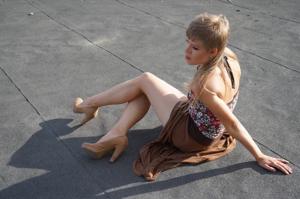 Beautiful fashionable sexy girl in high heels having fun on a skateboard  the roof.  the background of an abandoned factory. — Stock Photo, Image