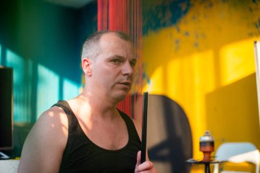 Adam kafede dinlenirken nargile içiyor. 