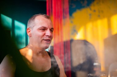 Adam kafede dinlenirken nargile içiyor. 