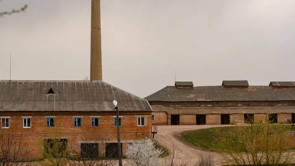 曇った空の下で工場の古い放棄された建物 — ストック写真