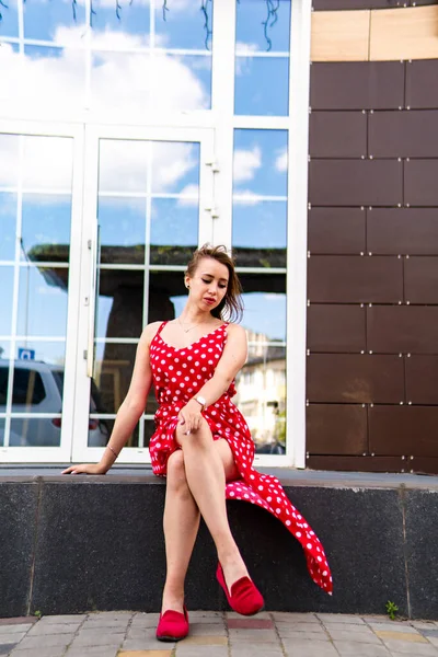 attractive young woman in summer red dress posing outdoor