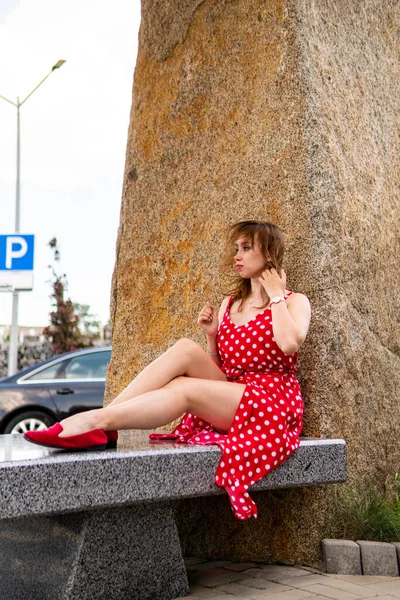 attractive young woman in summer red dress posing outdoor