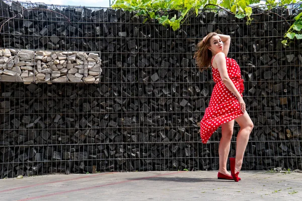 attractive young woman in summer red dress posing outdoor