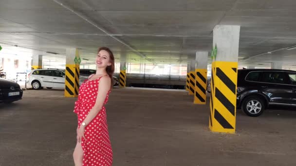 Νεαρή Γυναίκα Μακριά Μαλλιά Ένα Κόκκινο Φόρεμα Στο Πάρκινγκ — Αρχείο Βίντεο