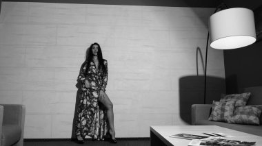 Odada poz veren güzel genç bir kadın, siyah beyaz bir fotoğraf.