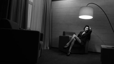 Odada poz veren güzel genç bir kadın, siyah beyaz bir fotoğraf.