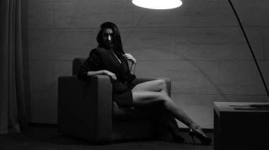 Odada poz veren güzel genç bir kadın, siyah beyaz bir fotoğraf.