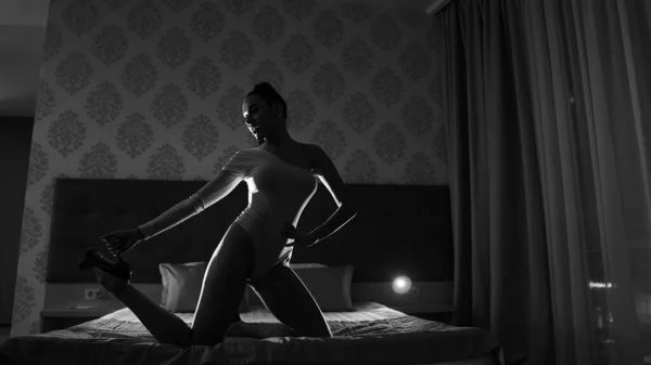 部屋のベッドの上でポーズをとっている美しい若い女性黒と白 — ストック写真