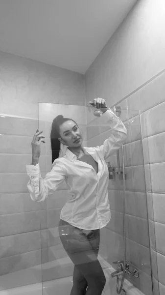 穿着男式衬衫的年轻貌美的女人在浴室里摆姿势 黑白照片 — 图库照片