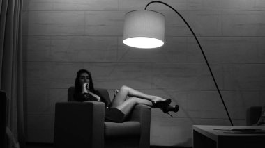 Odada poz veren güzel genç bir kadın, siyah beyaz bir fotoğraf.