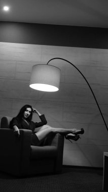 Odada poz veren güzel genç bir kadın, siyah beyaz bir fotoğraf.