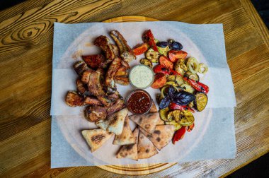 Kırmızı biber soslu tavuk kanadı. Kereviz çubuklarıyla sıcak servis edilmiş. Ve küflü peynir soslu havuç ve bira.