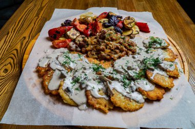 Kırmızı biber soslu tavuk kanadı. Kereviz çubuklarıyla sıcak servis edilmiş. Ve küflü peynir soslu havuç ve bira.