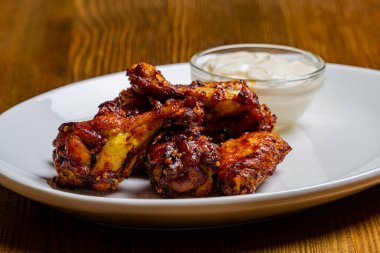 Tahta masadaki beyaz tabakta taze kızarmış tavuk..