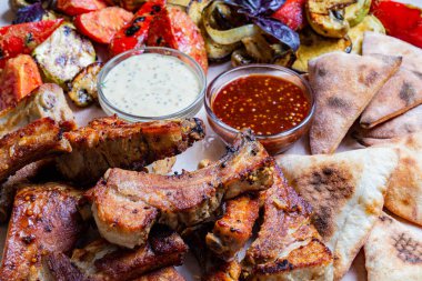 Kırmızı biber soslu tavuk kanadı. Kereviz çubuklarıyla sıcak servis edilmiş. Ve küflü peynir soslu havuç ve bira.