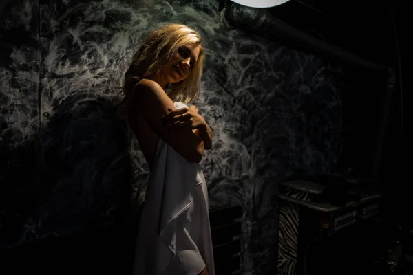 赤身裸体的金发姑娘 黑黑的背景上铺着白布 — 图库照片