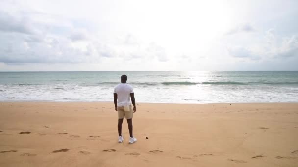Afro American sports guy looking at sea. — Stock Video