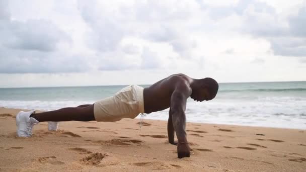 Afro-Amerikaanse sport guy uit te werken op het strand met een naakte top Rechtenvrije Stockvideo