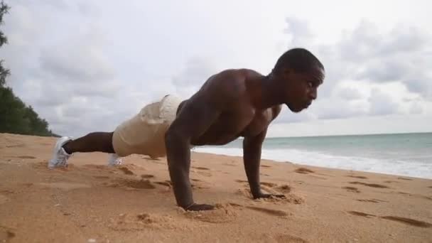 Afro-Amerikaanse sport guy uit te werken op het strand met een naakte top Rechtenvrije Stockvideo's