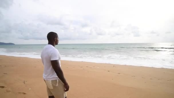 Afro amerikansk sportkille tittar på havet. — Stockvideo