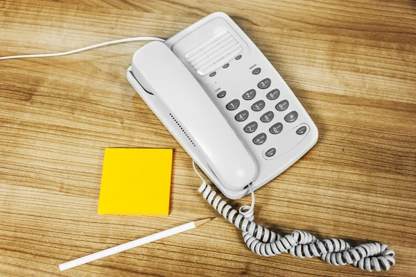 Telefone branco em uma madeira de mesa — Fotografia de Stock