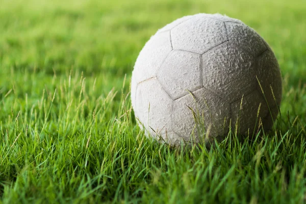 Piłka nożna na zielonej trawie z miękkiego światła — Zdjęcie stockowe