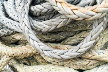 Çeşitli örgülü iplerin yakın çekimi karmaşık dokular ve doğal tonlar sergiliyor. Denizcilik, el sanatları ve kırsal tasarımlarla ilgili projeler için ideal..