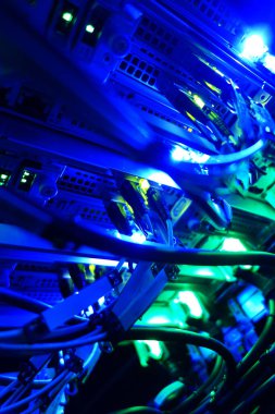 Renkli LED ışıklarıyla aydınlatılan, modern teknoloji ve dijital iletişim altyapısının sergilendiği ağ kablolarının ve sunucu ekipmanlarının canlı yakın çekimi.